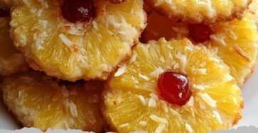 Pineapple Upside Sugar Cookies Ingredients: - 1 cup unsalted butter, softened - 1 cup granulated sugar - 1 large egg - 1 teaspoon vanilla extract - 2 1/2 cups all-purpose flour - 1/2 teaspoon baking powder - 1/4 teaspoon salt - 1/2 cup crushed pineapple, drained - 1/2 cup brown sugar - 1/4 cup unsweetened shredded coconut - Maraschino cherries (optional, for garnish) Directions: 1. Preheat oven to 350°F (175°C). Line baking sheets with parchment paper. 2. In a large bowl, cream together the butter and granulated sugar until light and fluffy. 3. Beat in the egg and vanilla extract until well combined. 4. In a separate bowl, whisk together the flour, baking powder, and salt. 5. Gradually add the dry ingredients to the wet mixture, mixing until just combined. 6. Fold in the crushed pineapple and shredded coconut evenly into the dough. 7. In a small bowl, mix the brown sugar with a little flour to prevent spreading. 8. Scoop tablespoon-sized portions of dough and roll into balls. 9. Roll each dough ball in the brown sugar mixture, then place on the prepared baking sheets about 2 inches apart. 10. Flatten each cookie slightly with the palm of your hand or the bottom of a glass. 11. If desired, press a maraschino cherry into the center of each cookie. 12. Bake for 12-15 minutes or until the edges are golden and the cookies are set. 13. Allow cookies to cool on the baking sheet for 5 minutes before transferring to a wire rack to cool completely. Prep Time: 15 minutes | Cooking Time: 15 minutes | Total Time: 30 minutes Kcal: 180 kcal | Servings: 24 cookies Tips: For extra tropical flavor, add a teaspoon of finely grated lime zest to the dough. Make sure to drain the pineapple well to prevent cookies from becoming too moist.